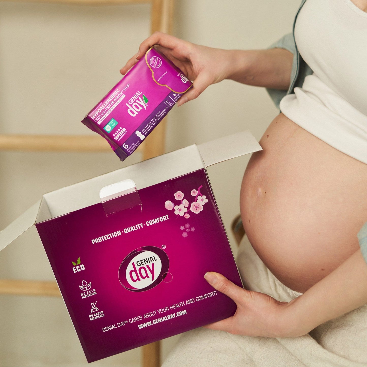 Pregnant woman holding Genial Day postpartum kit