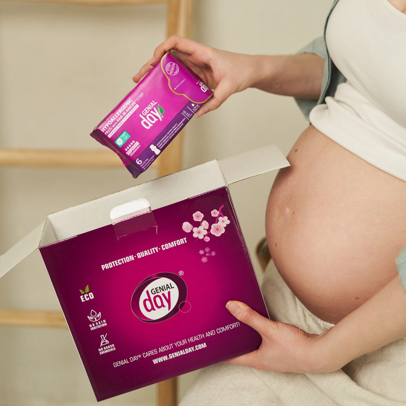 Pregnant woman holding Genial Day postpartum kit