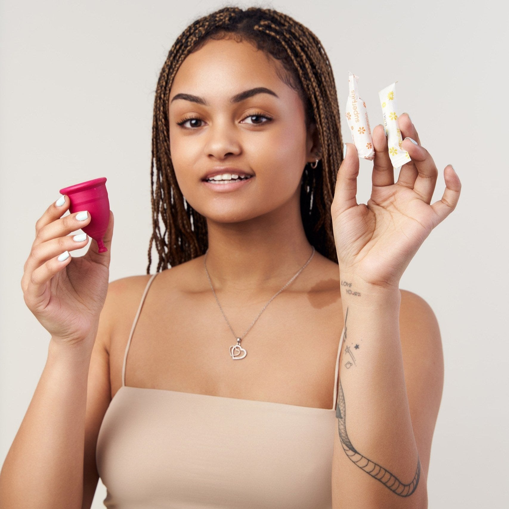Girl holding Genial Day menstrual cup made of TPE and tampons